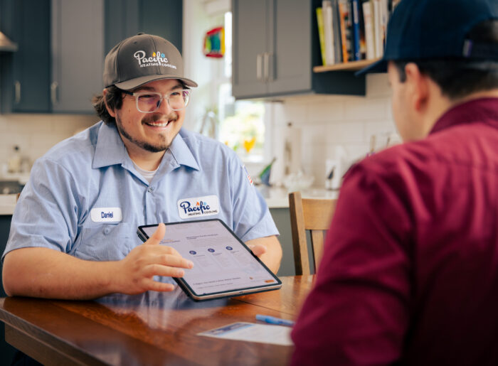 Friendly Tacoma plumber discussing plumbing service options with a homeowner at their kitchen table