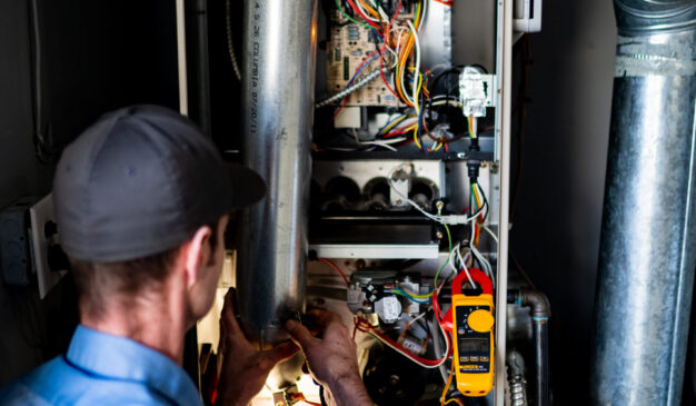 Pacific Heating and Cooling technician servicing a furnace or air handler for a diagnostic or tune-up service