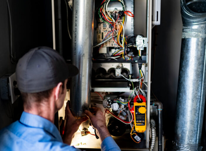 Pacific Heating and Cooling technician servicing a furnace or air handler for a diagnostic or tune-up service