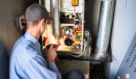 Pacific Heating and Cooling technician servicing a furnace or air handler for a diagnostic or tune-up service