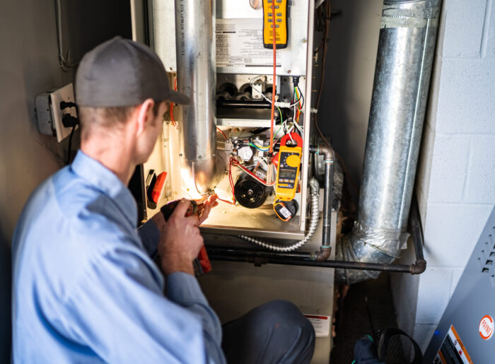 Pacific Heating and Cooling technician servicing a furnace or air handler for a diagnostic or tune-up service