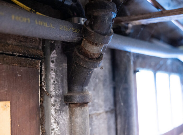 Close-up of old corroded galvanized steel pipes and fittings in a Tacoma home, showing age and wear that call for repiping