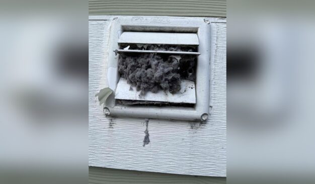 Clogged dryer vent covered in lint before a Tacoma cleaning visit Placement: directly under the H1, above the opening paragraph Why hero: it's a real, striking 