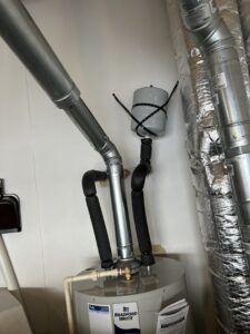 Water heater expansion tank mounted on the cold water line above a gas water heater