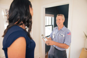Pacific Heating and Cooling technician explaining HVAC maintenance to a homeowner