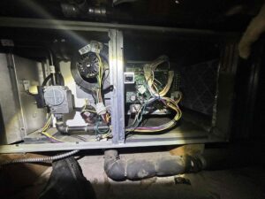 Open furnace panel showing control board, inducer motor, and gas valve during a no heat diagnostic in Western Washington