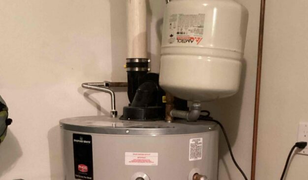 Water heater expansion tank mounted on the cold water line above a gas water heater