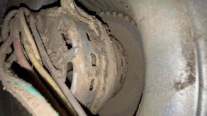 Blower motor caked with dust and debris inside a furnace, which can cause weak airflow from vents in a house