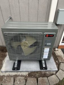 Covington heat pump installation: new Trane heat pump outdoor unit on a pad beside the home