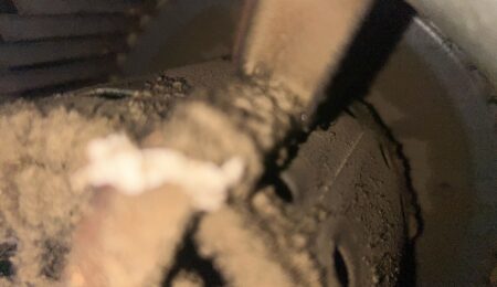 Dirty blower wheel caked with dust, a common cause of low airflow from vents in a home HVAC system