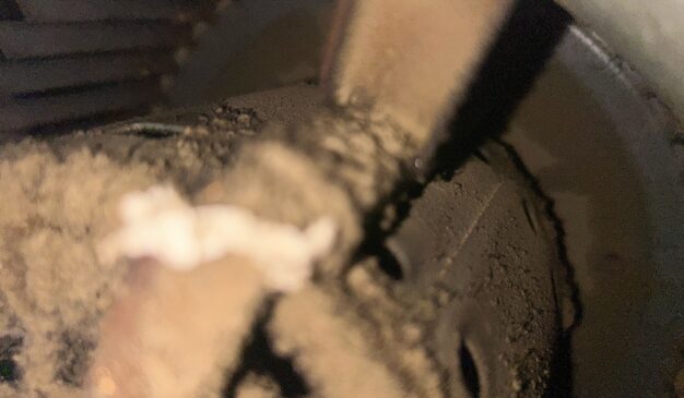 Dirty blower wheel caked with dust, a common cause of low airflow from vents in a home HVAC system