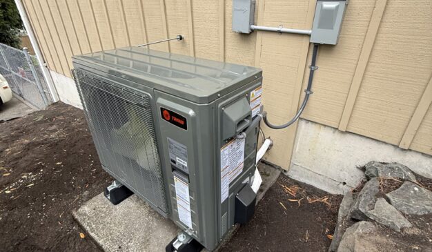 Tacoma heat pump installation with a new Trane outdoor unit beside the home